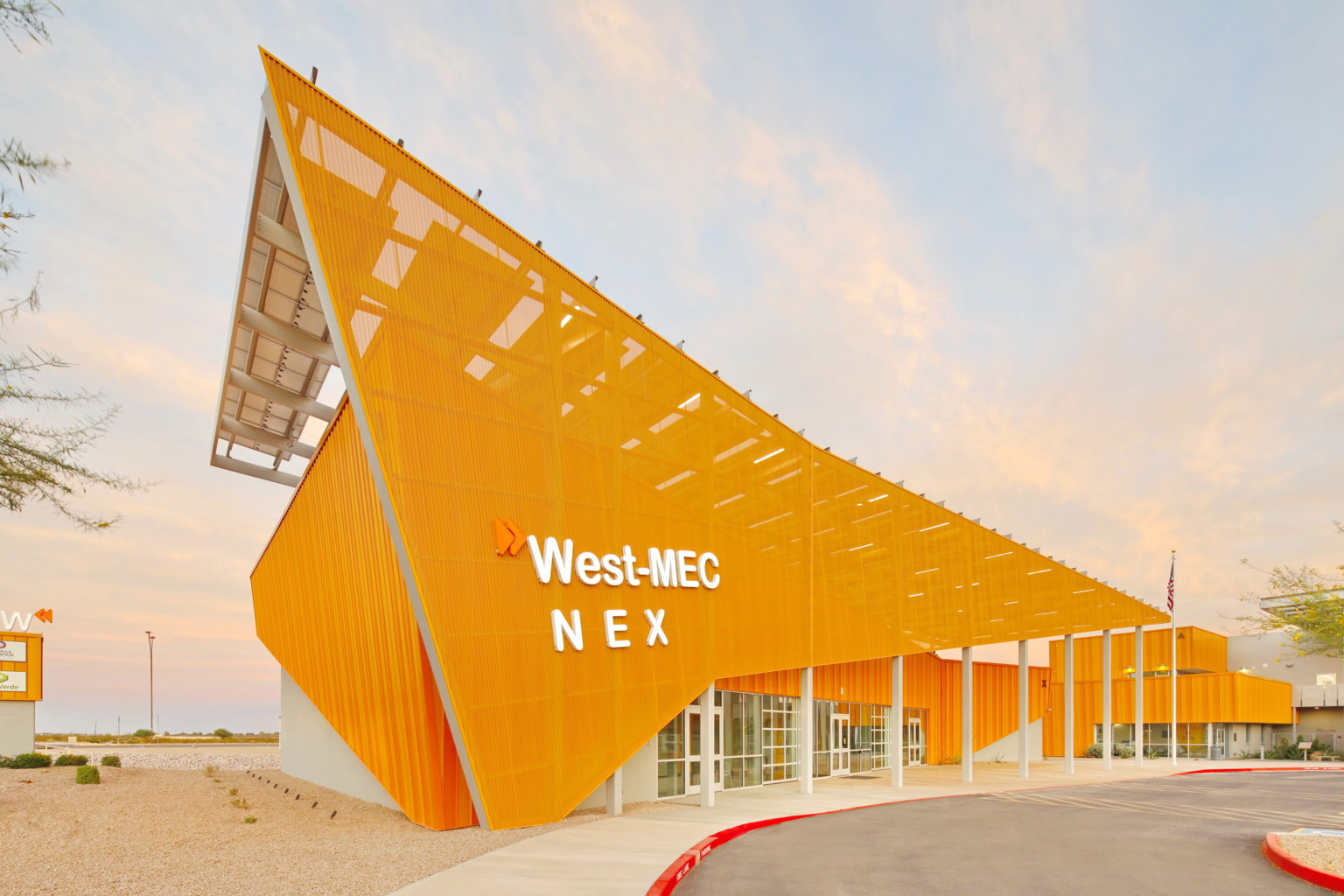 West-MEC NEX building at the Southwest Campus, an angular yellow building with sunscreen across the front with white sign