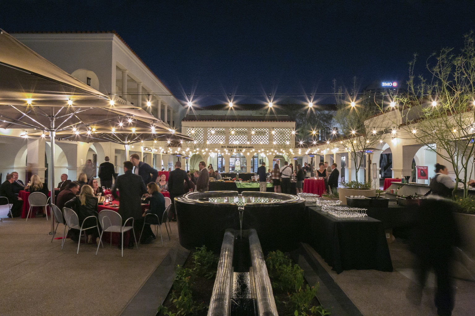 The same courtyard at an evening event, illuminated from the building interior and the lights strung through the area