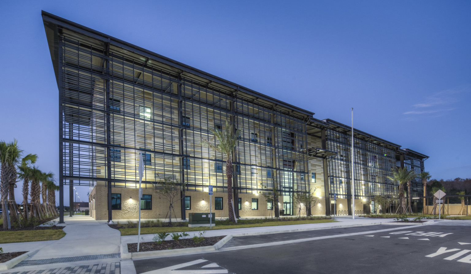 Stone building at the Poinciana Campus of Valencia College with large roof overhang and geometric design wrapping building