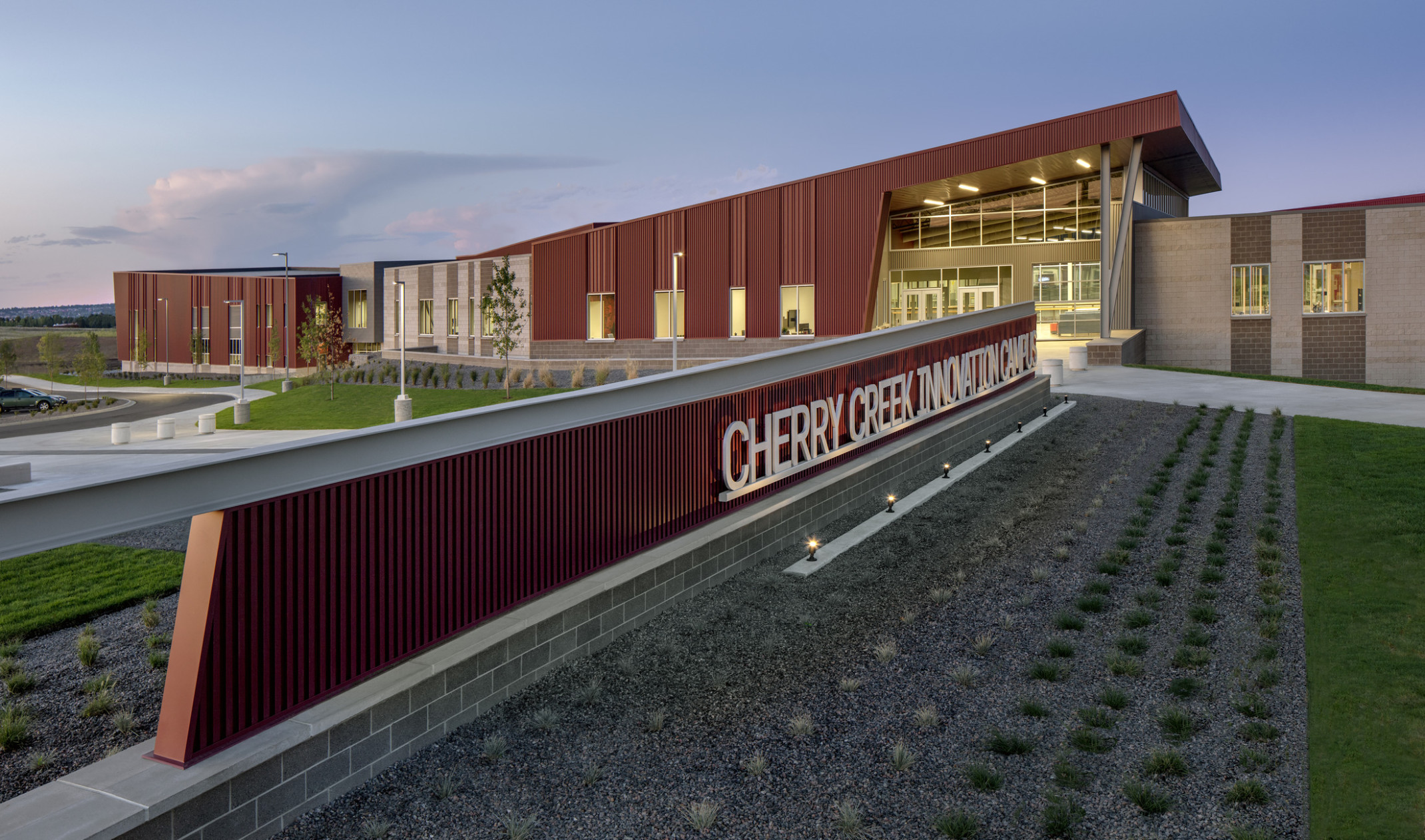 Cherry Creek Career and Innovation Academy Campus entrance, a red panel building with long sign and canopy over glass entry Cherry Creek Career and Innovation Academy Campus entrance, a red panel building with long sign and canopy over glass entry