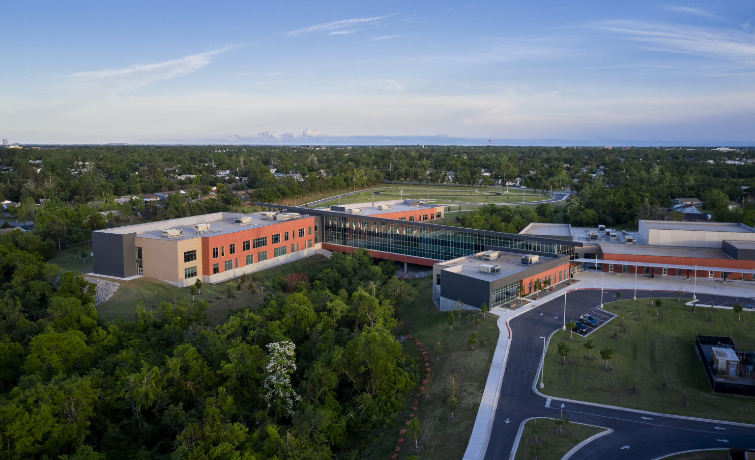 Capps Middle School viewed from above. A round driveway leads to front entrance. A long windowed hall connects 2 buildings