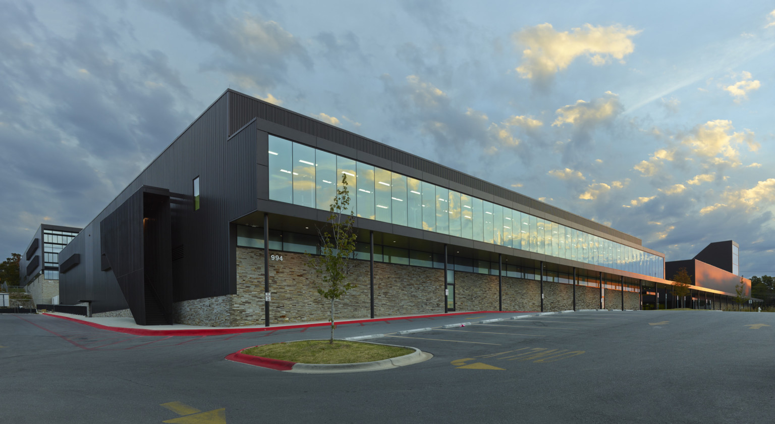 Fayetteville High School 2nd floor with seamless window hallway extends to create covered walkway above stone wall to entry