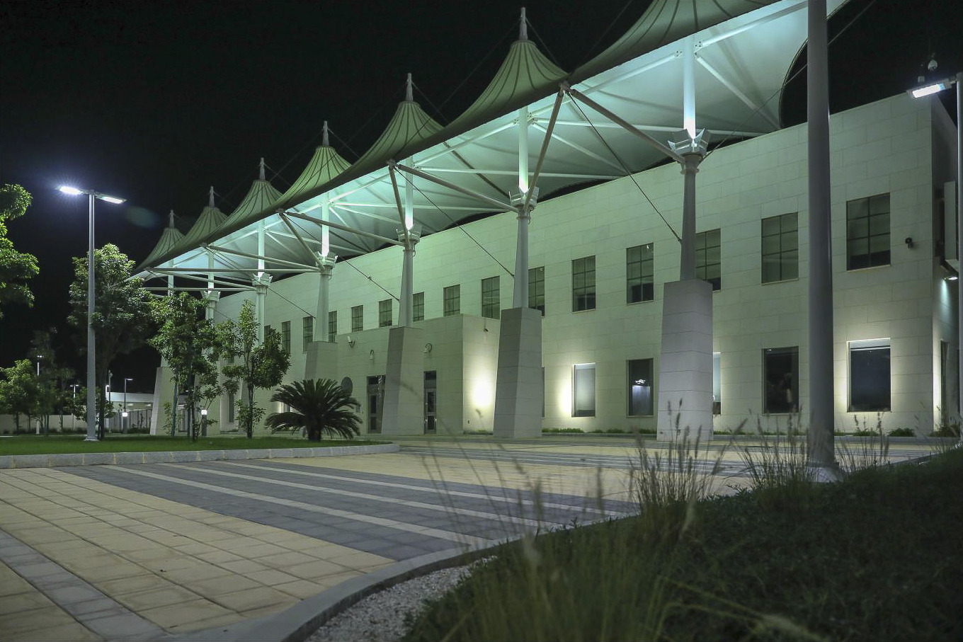 The U.S. Consulate in Jeddah is a white stone angular building with first floor entry outcrop. Pillars with stone base front