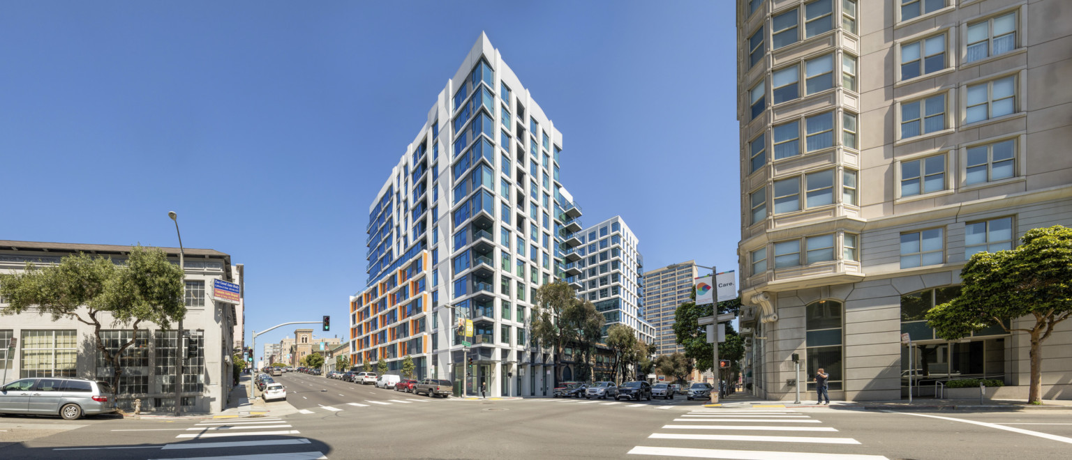 Oyster Development Portfolio building viewed from opposite corner. A glass building with white seams and orange accents