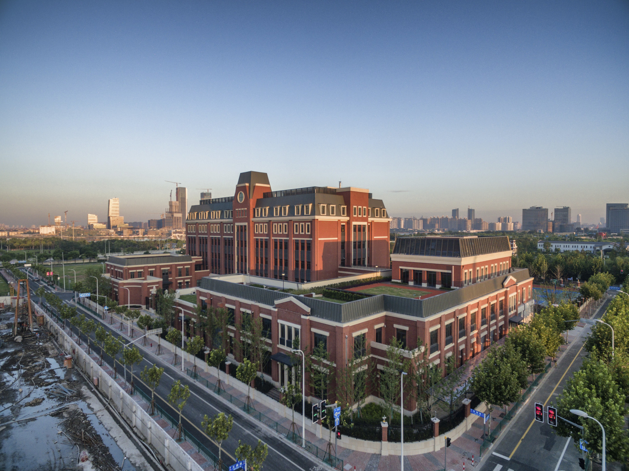 Huili International School, a brick building with green roof patios, exterior view from above on a clear day