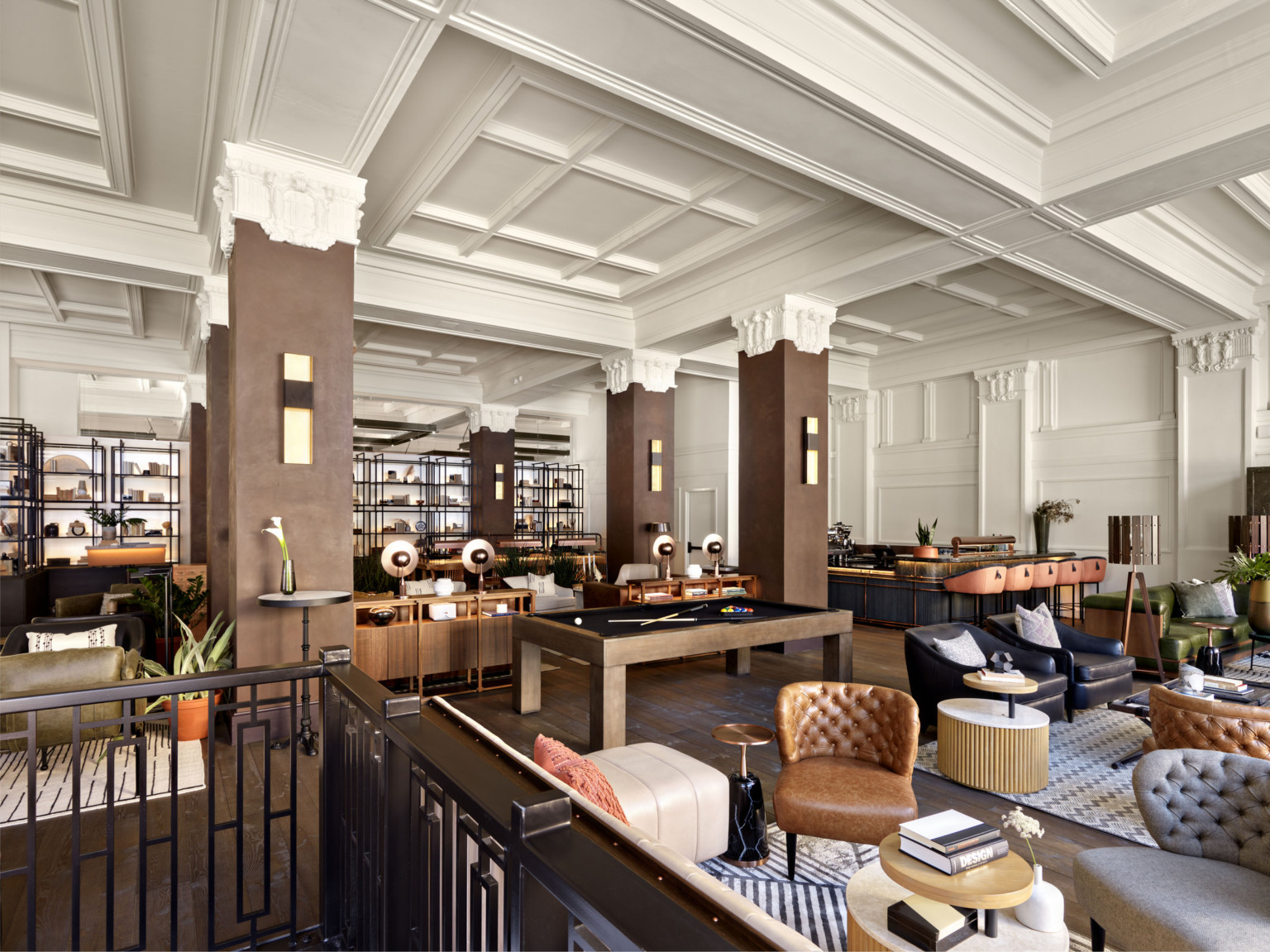 Seating area in the Surety Hotel with wood pillars and white stone capitals in white room with recessed ceiling details