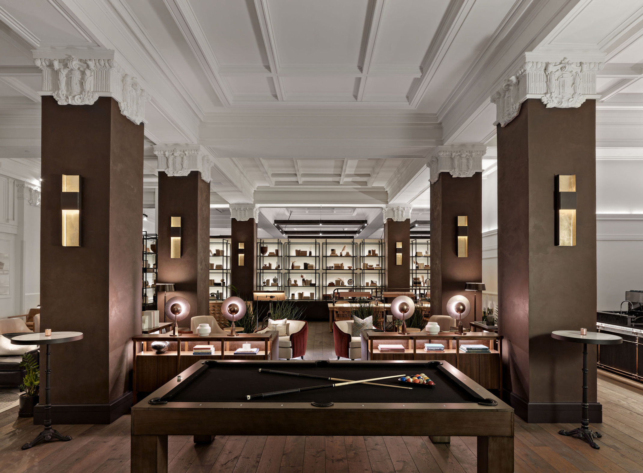 The Surety Hotel with billiard tables and wood pillars and white Corinthian capitals in room with recessed ceiling details