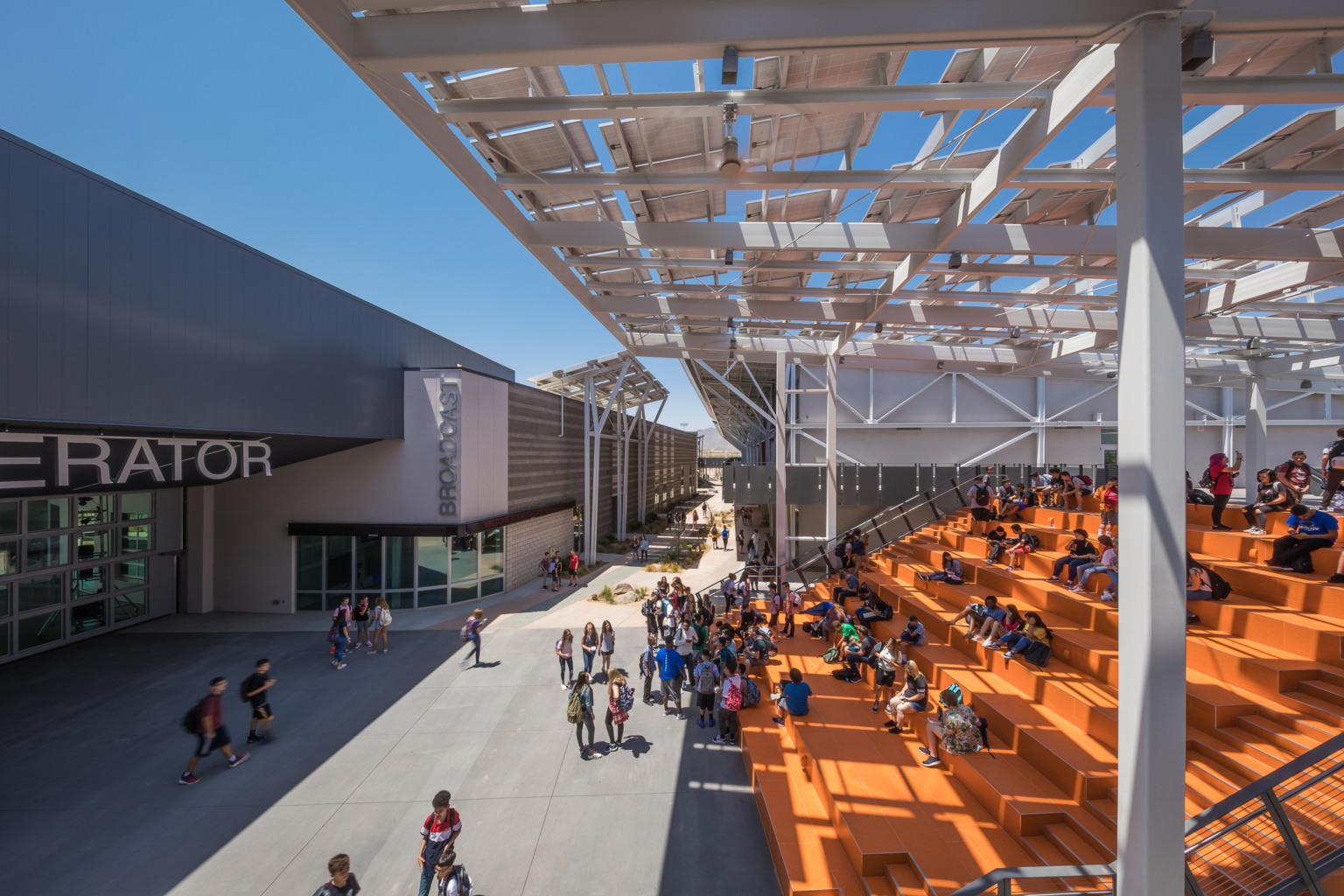 orange bleacher seating shaded by a solar panel canopy