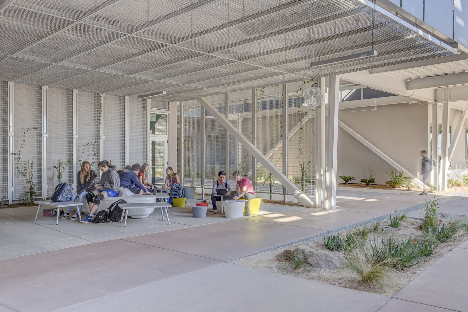 A seating area off a path partially shaded by solar panels