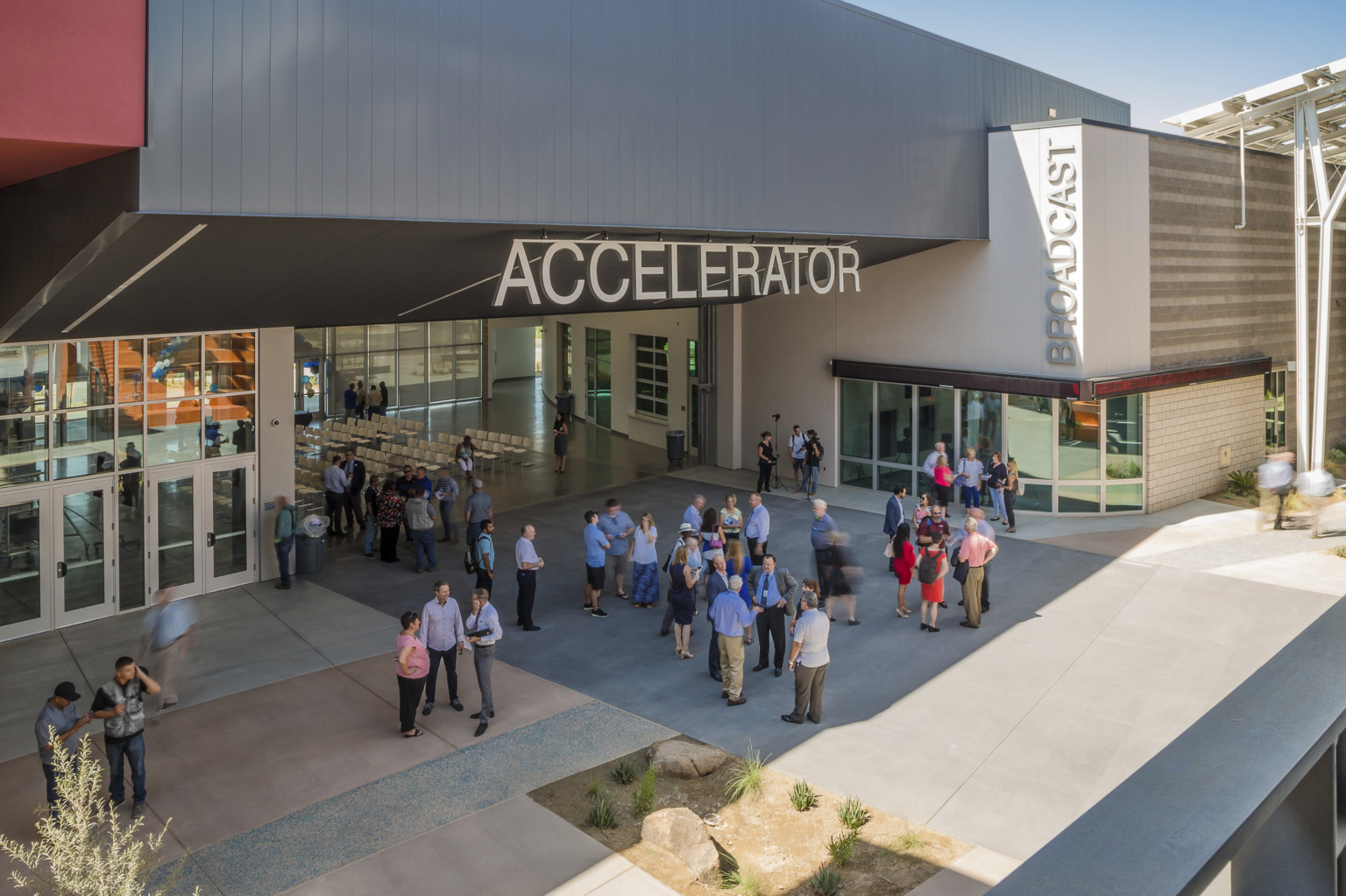 Section of building labeled Accelerator has an angled black roof above wall opening up a seating area to the patio