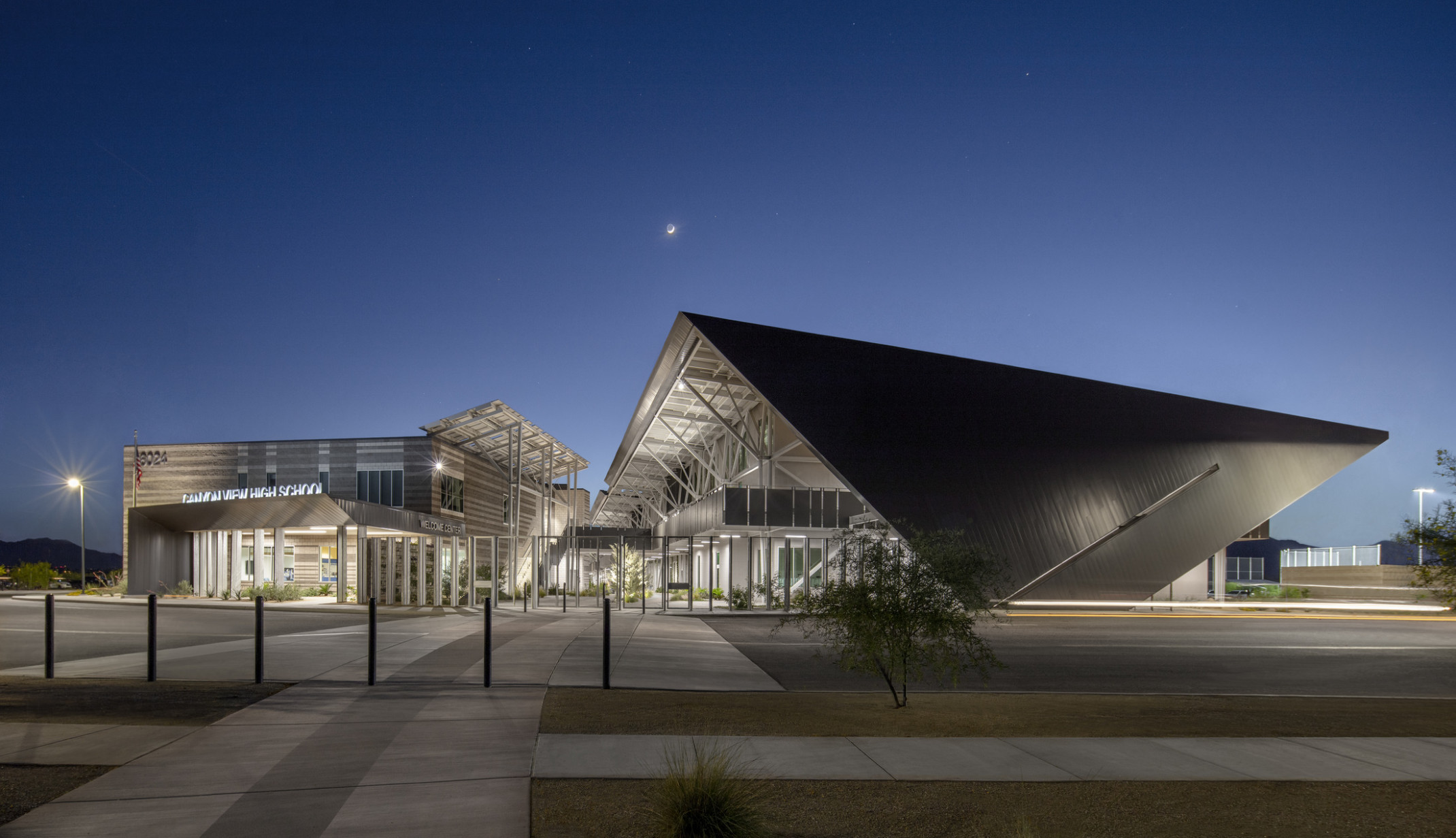 Modern steel building with exposed structural beams and solar canopies, night photography, steel roof, school, high school Modern steel building with exposed structural beams and solar canopies, night photography, steel roof, school, high school