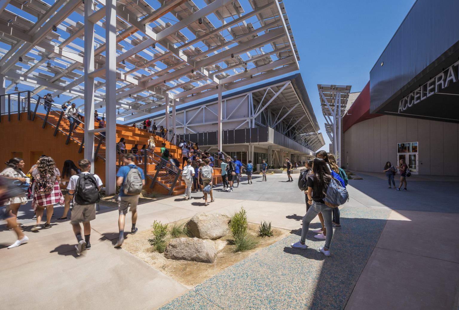 At the front of a walkway between buildings is a large orange partially covered staircase