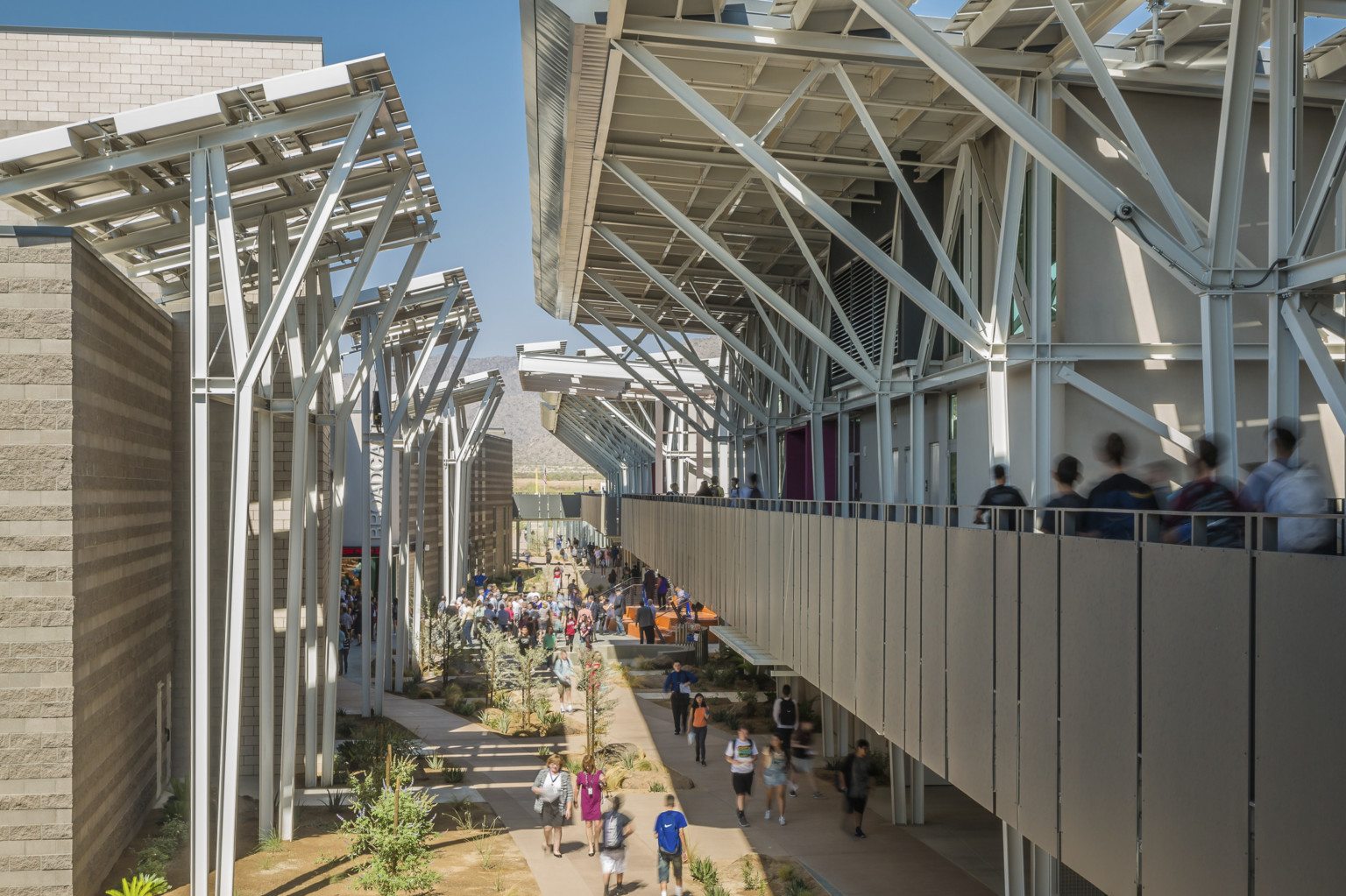 A second floor exterior partially covered walkway is framed on both sides by exposed structural beams