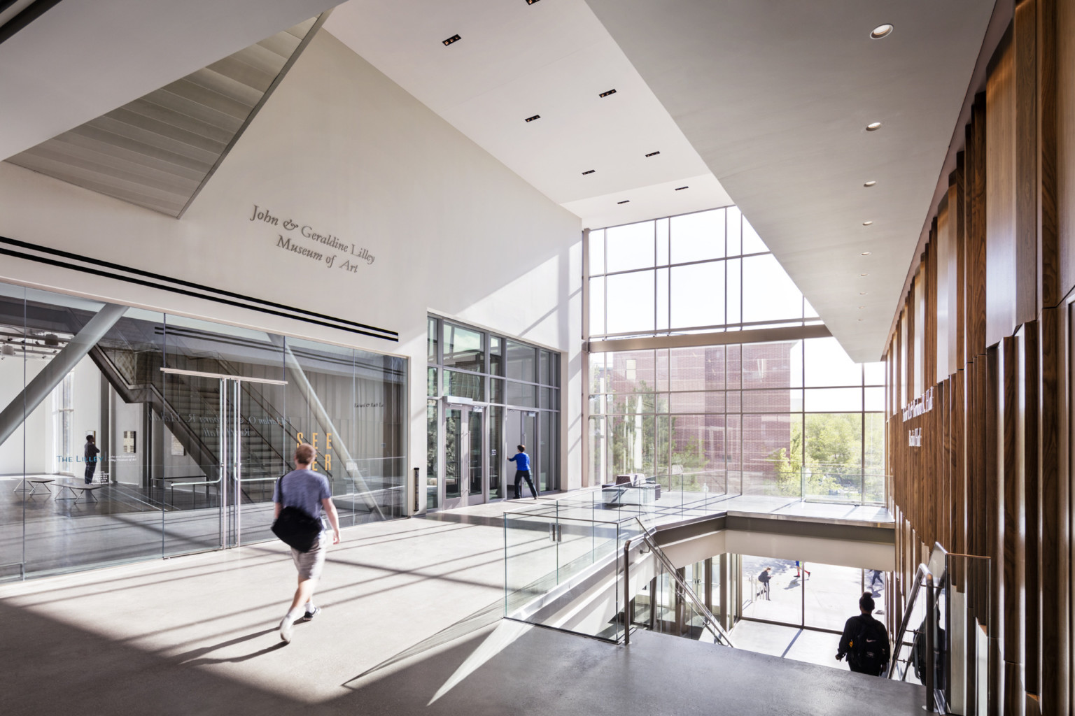 students walk through multistory lobby with angular ceiling