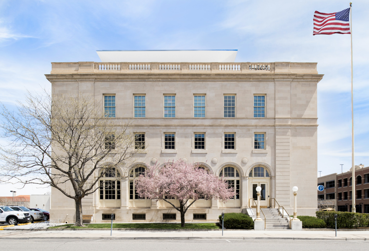 The historic Wayne Aspinall Federal Building with a flowering pink tree in the foreground
