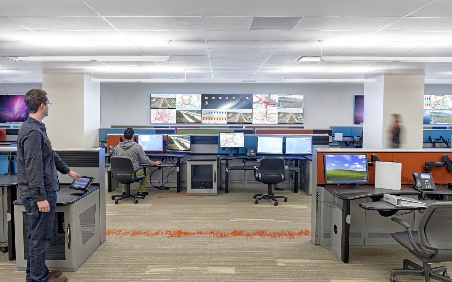 San Francisco Municipal Transportation Agency Transit Management Center office with screens on opposite wall and each desk