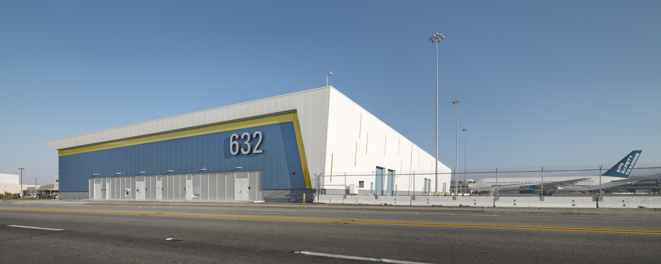 San Francisco International Airport’s West Field Cargo Facility, a blue yellow and white wrapped facade building beside plane