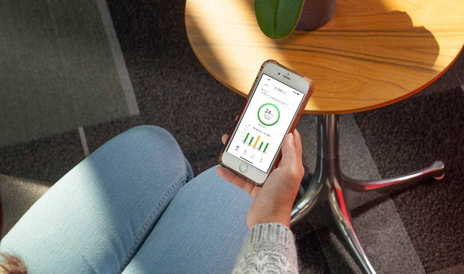 person using an app in a space to read live air quality metrics