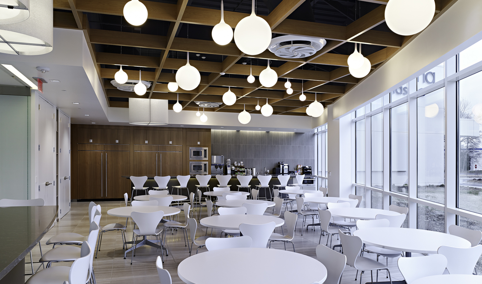 dining space with white tables and chairs, wood panel ceiling, and white round bulb pendant lighting