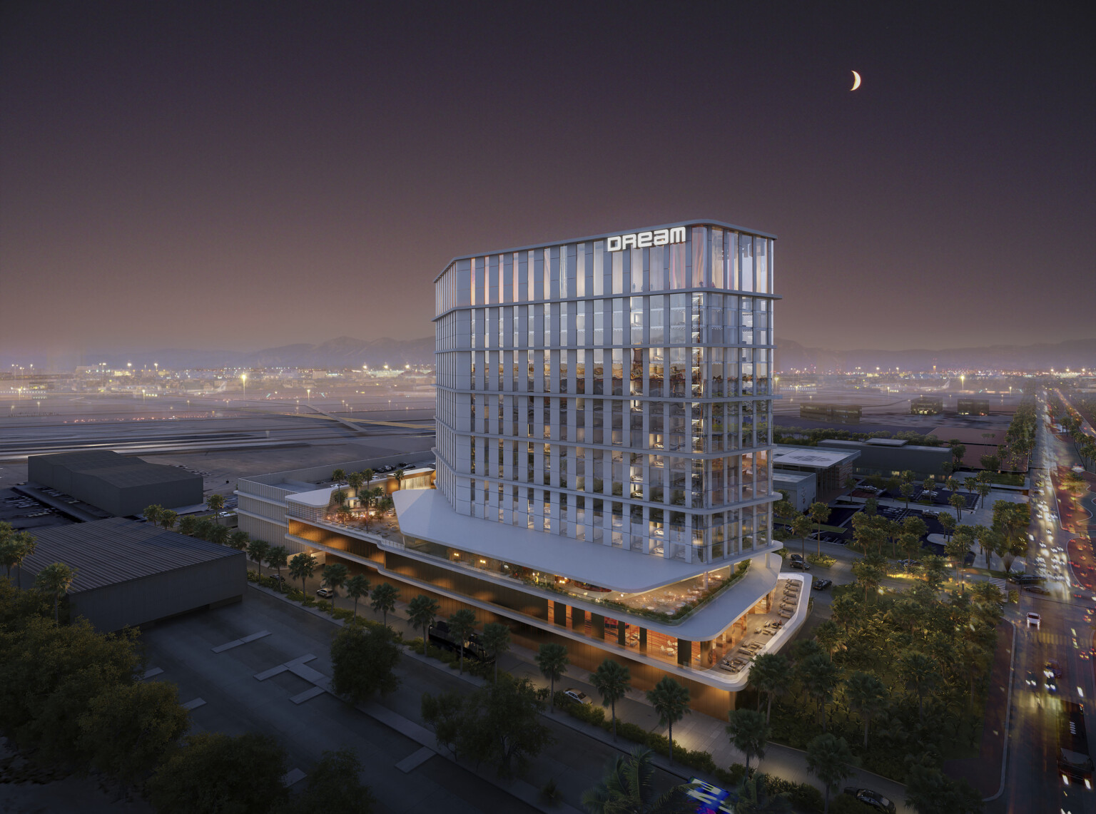 Hotel viewed from corner from above after dark, stepped balconies extend in two angled directions