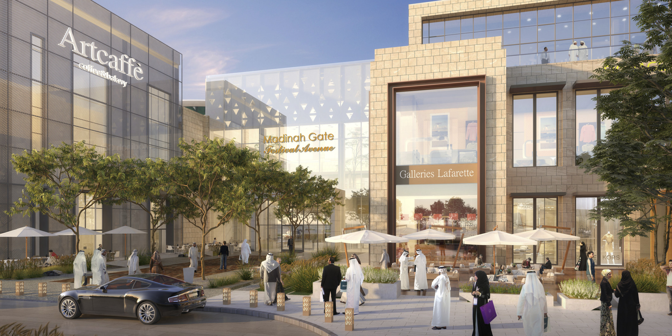 Madinah Gate, a glass and light stone mixed use building with gold accents. In front, tables with white umbrellas and chairs