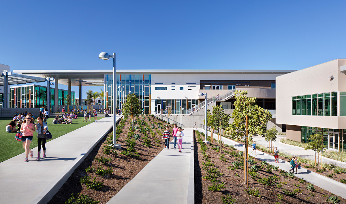 multi level pathways in courtyard of Design39 campus. White building with multicolor glass in double height window section