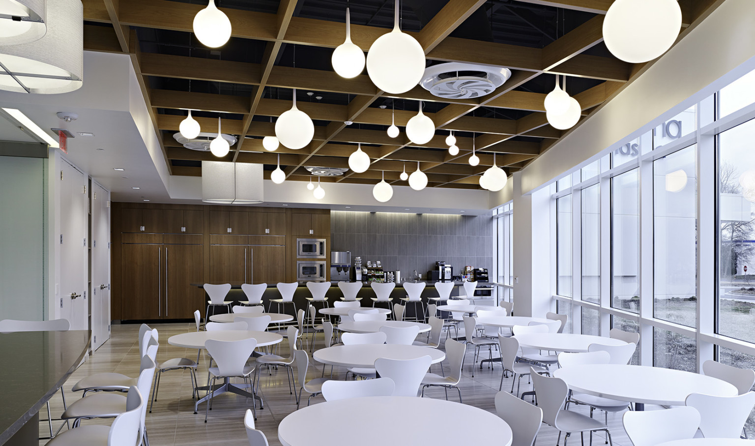 dining space with white tables and chairs, wood panel ceiling, and white round bulb pendant lighting