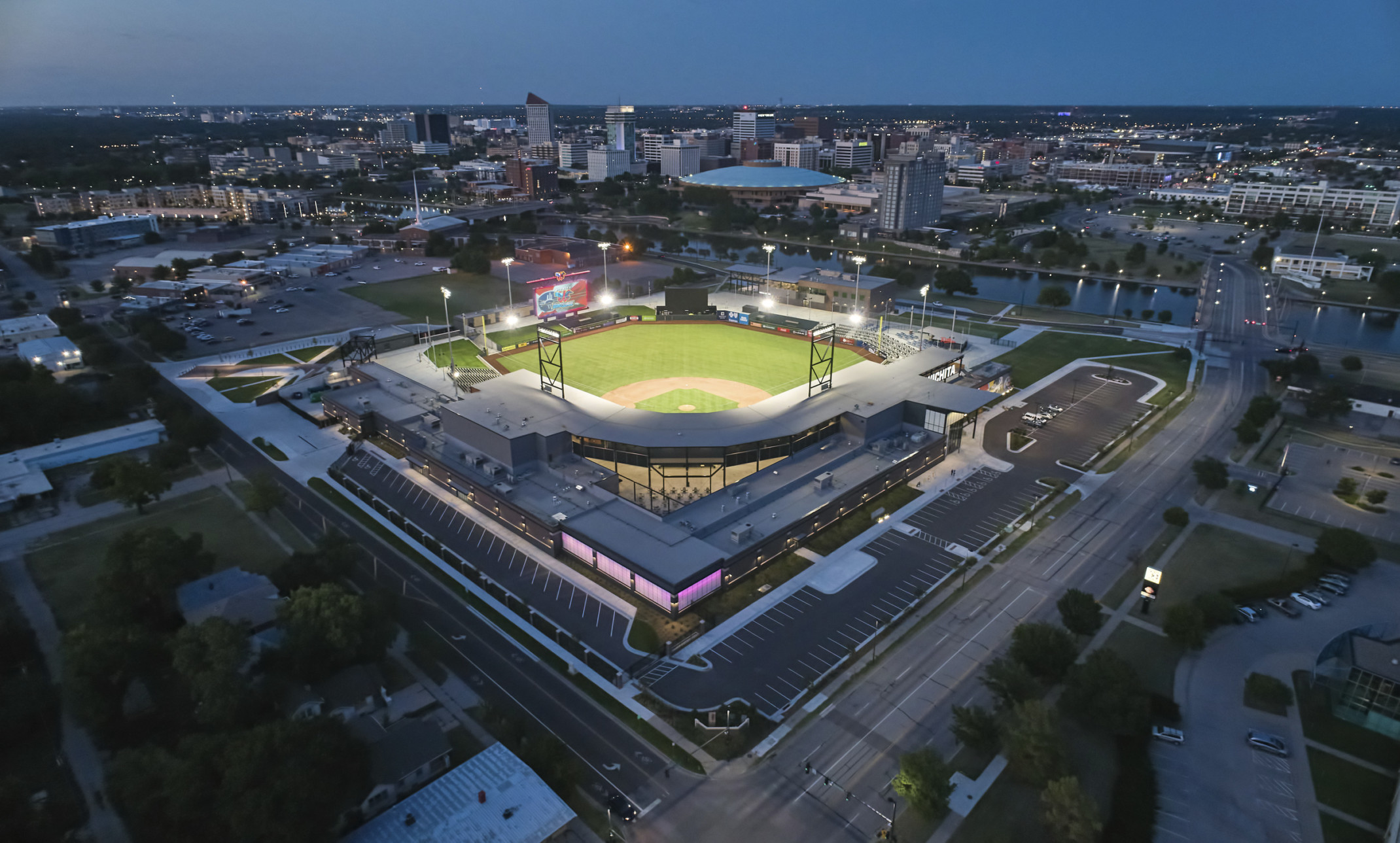 Riverfront Stadium home of the Wichita Wind Surge aerial view with baseball field illuminated at night