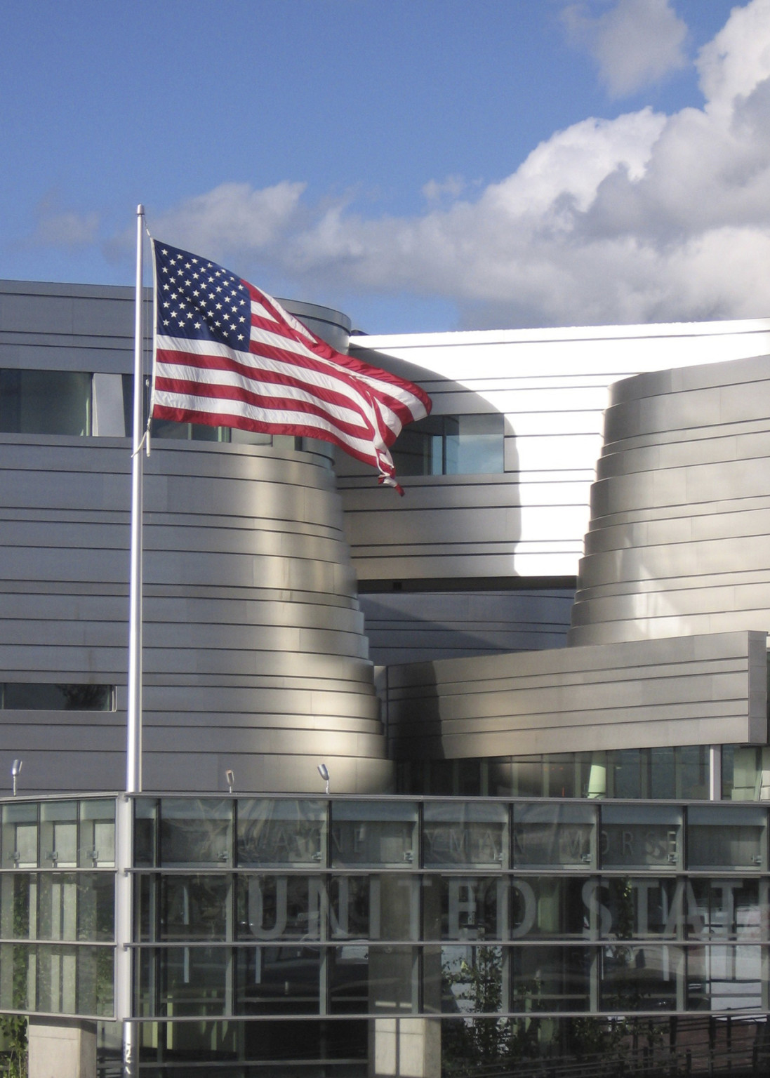 curved metal facade behind an american flag