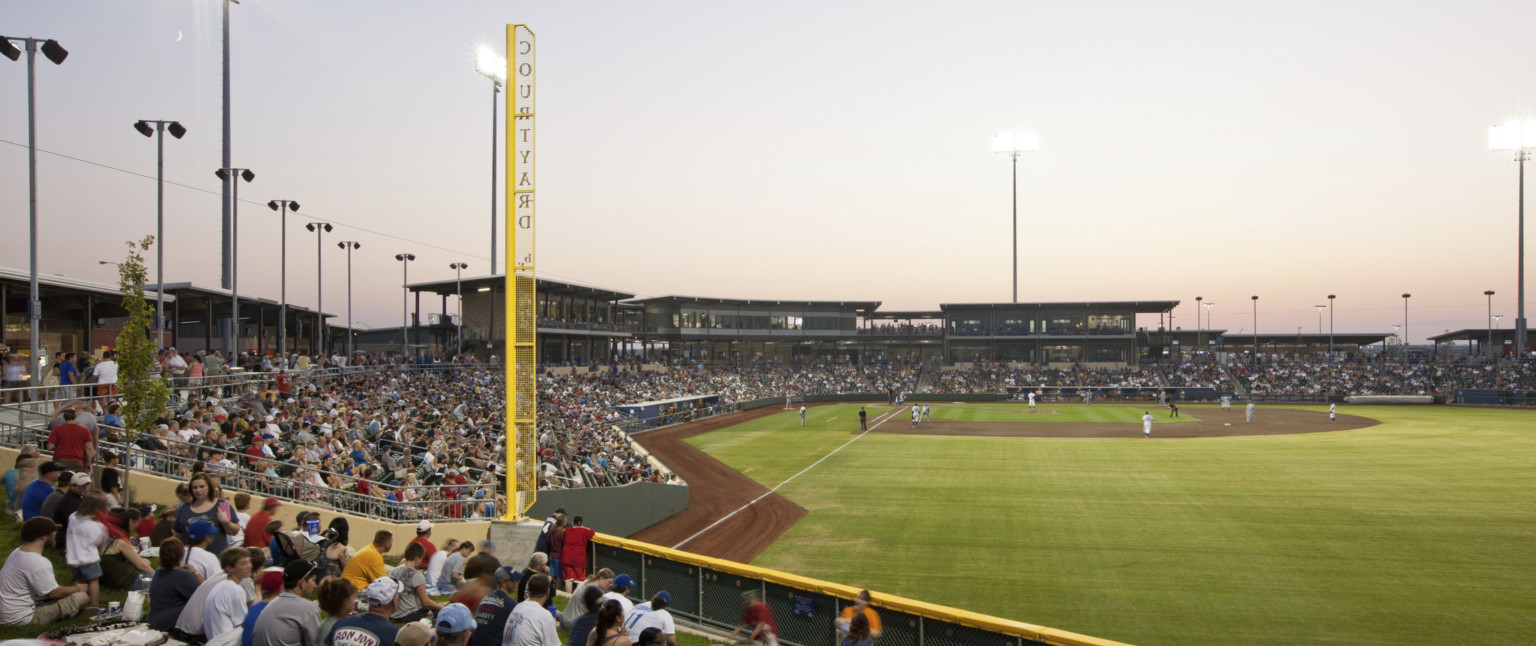 Lower deck seating at right field with yellow perforated metal foul line labeled Courtyard. View of box seats by home plate