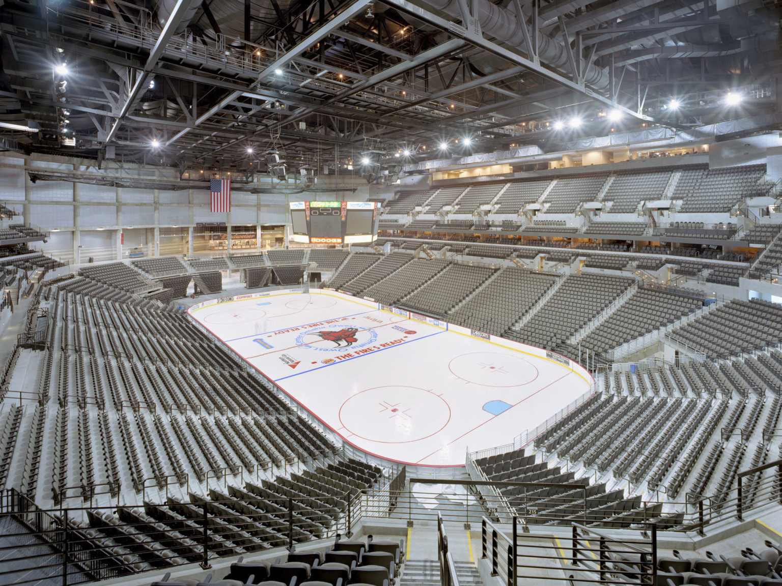 The basketball court converted to ice rink. The stadium seats are empty and their is a gap in the upper seating bowl.