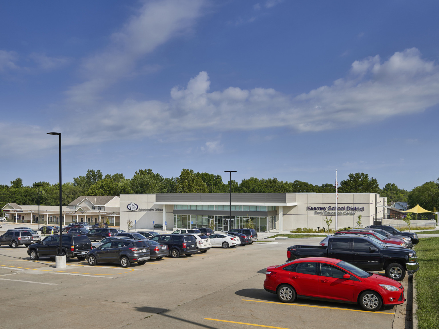 gray concrete building exterior and full car parking lot