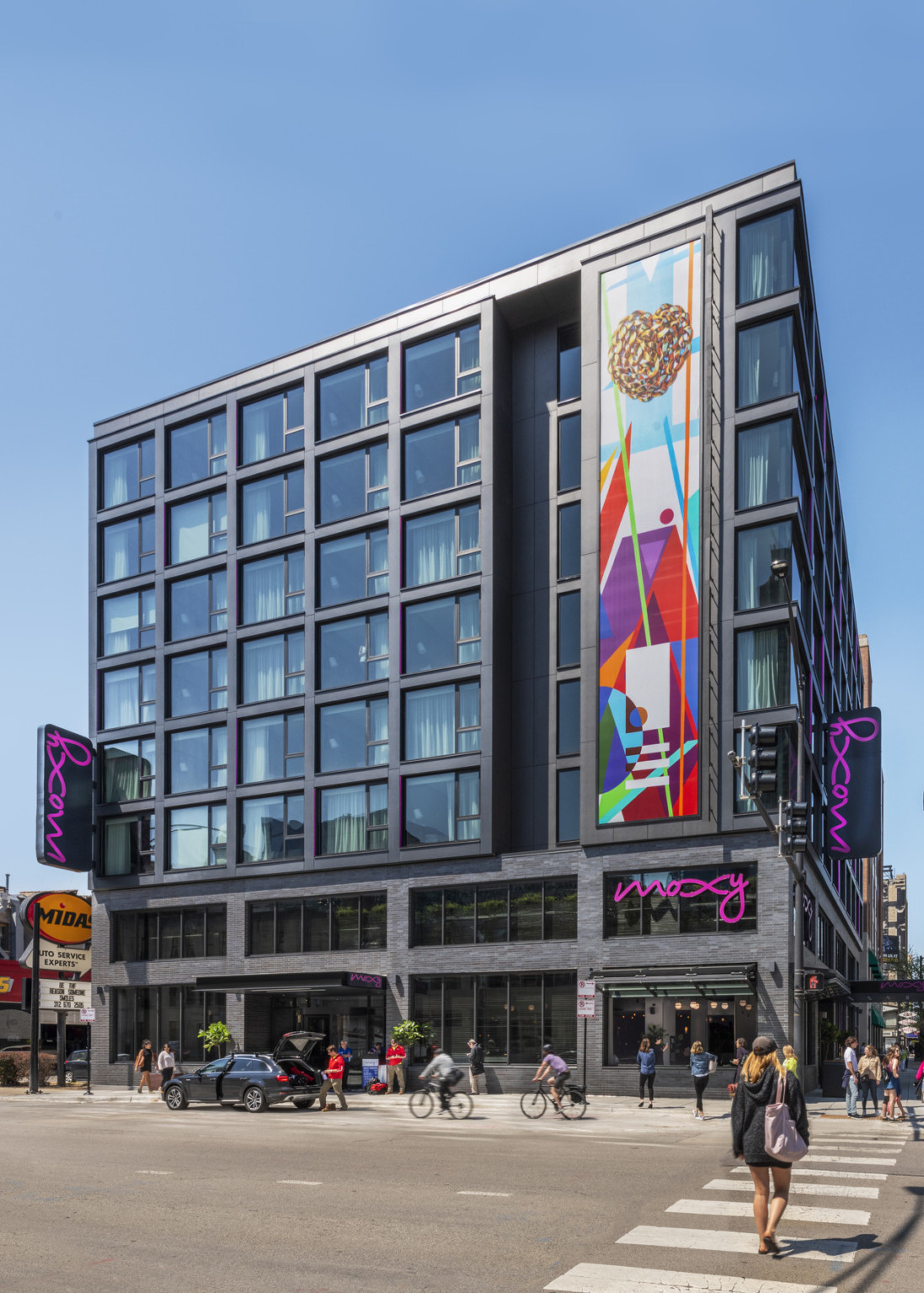 The hotel viewed from across the street with dark brick bottom floors below 6 Miessian floors, windows left of mural recessed