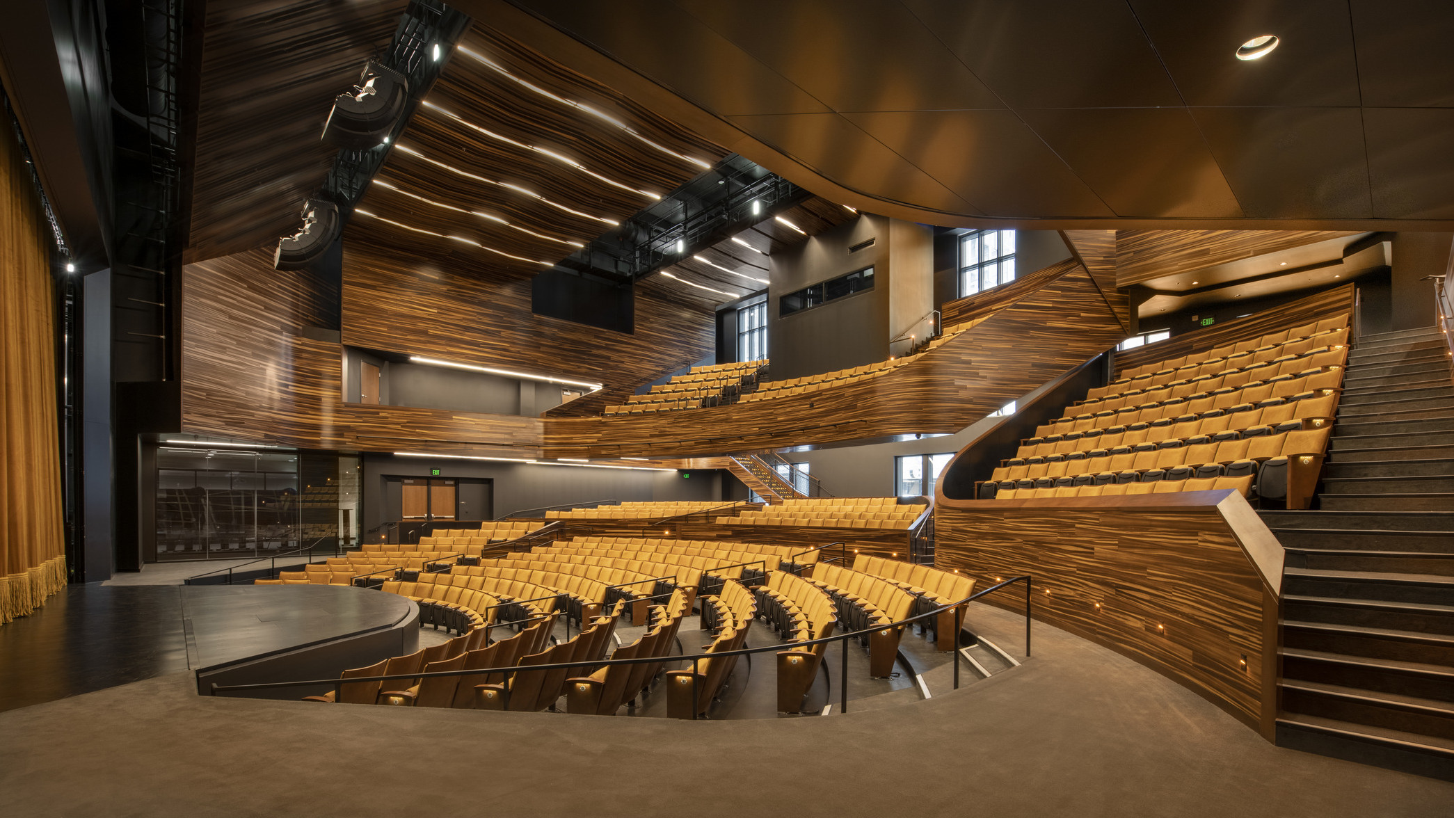 theater with wooden finishes and yellow seating, stairs on the right to balcony at Point Park University Pittsburgh Playhouse