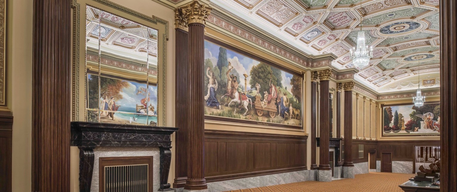 carpeted hallway with corinthian columns and colorful ceiling frescoes and large scale wall murals