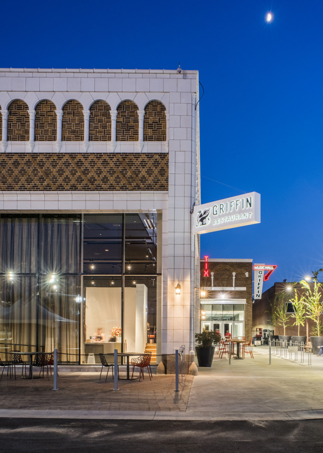 White stone details on building with geometric brick design, a white sign hangs from the corner reading Griffin Restaurant