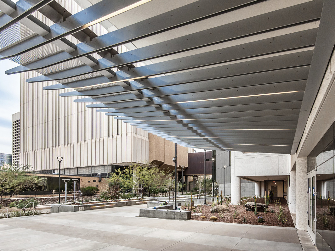 metal fin canopy shade over concrete courtyard with native desert landscaping