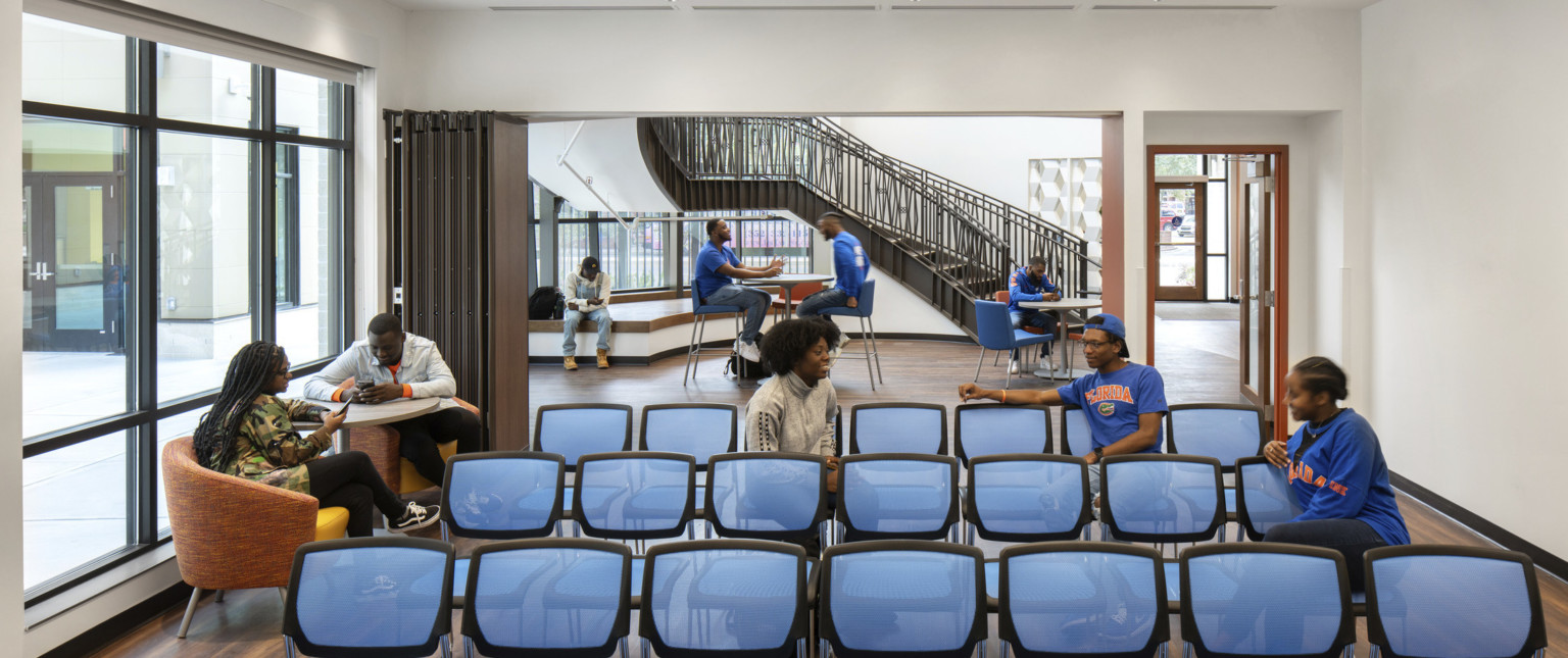 Off the main lobby with high tables and chairs, a room with flexible wall and chairs facing forward. More seats near windows