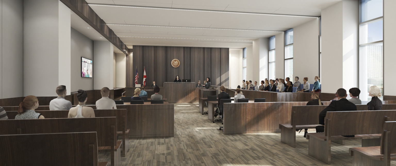 A white courtroom with dark wood accent walls and furniture. Floor to ceiling window panels along right wall behind jury box