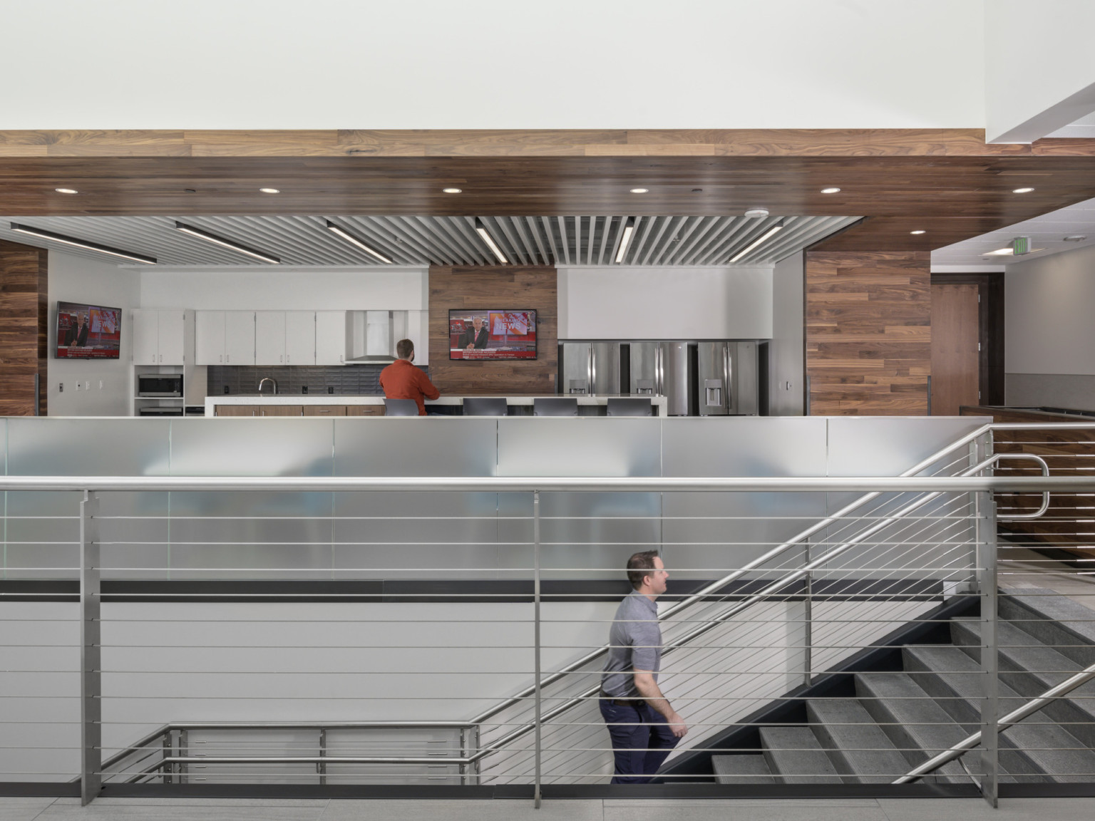 Interior stairwell to kitchen with wood details on walls and mixed media ceiling