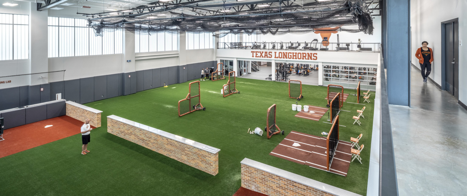 2nd floor walkway, training equipment on far end, looking down to turf floor practice space. Open floor plan to weight room