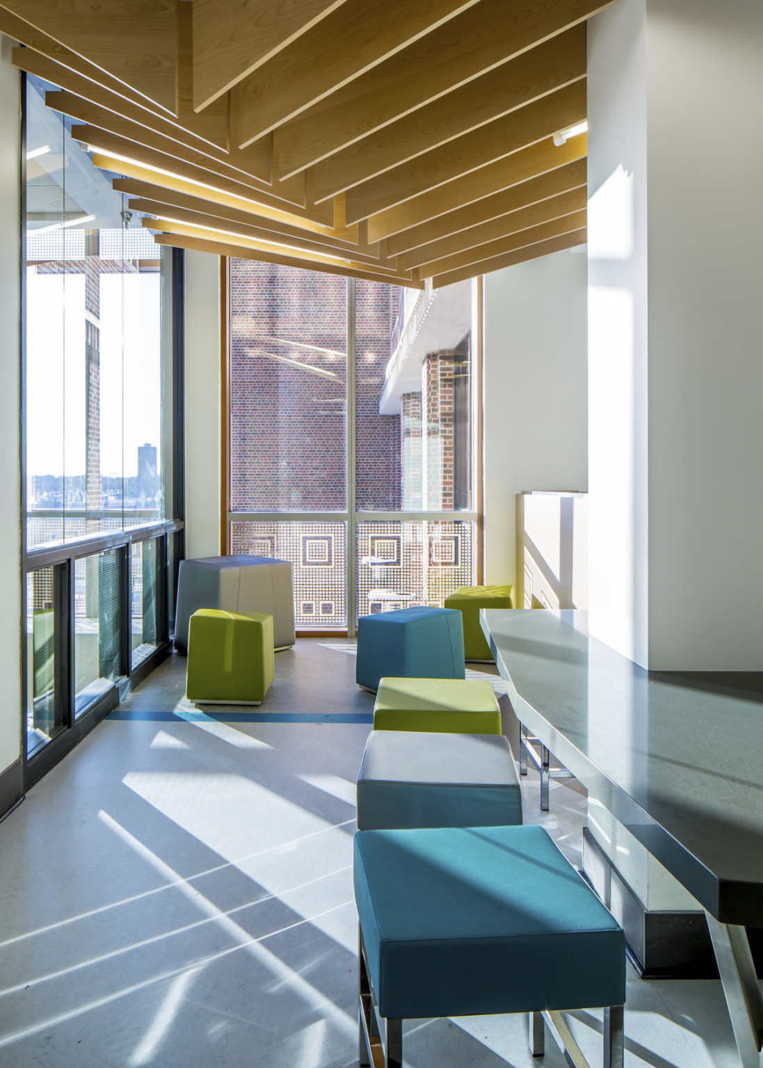 Colorful seating with floor to ceiling windows and angled wood slat ceiling at the University of Minnesota cultural center