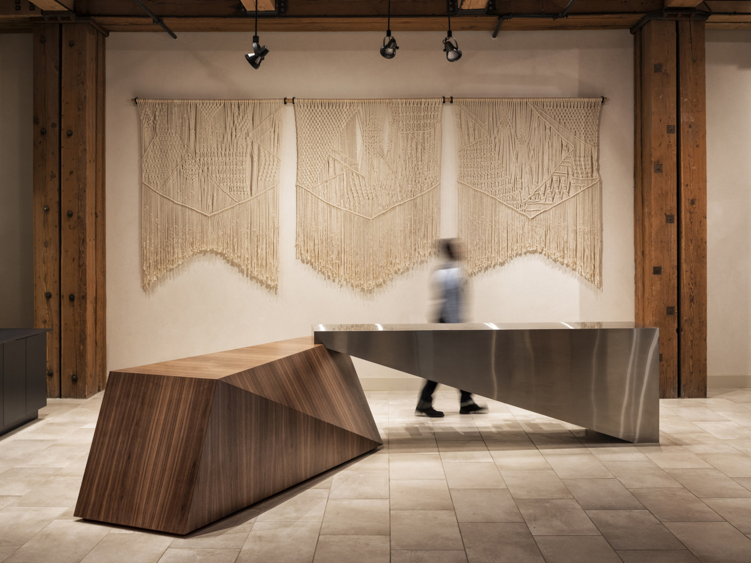 hotel front desk designed as a sculptural art piece, macrame art hangs on the background wall, adaptive reuse hotel, exposed wood
