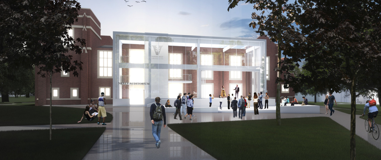 Exterior view of illuminated building with sign reading Neely Auditorium. Outdoor seating area right, in front of stage space