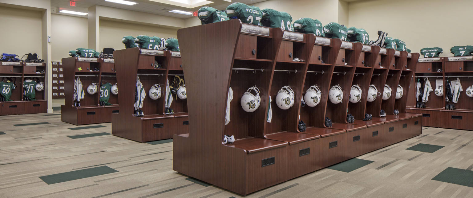 Wood lockers line the room and form rows through the center. Space for hung equipment behind bench and above