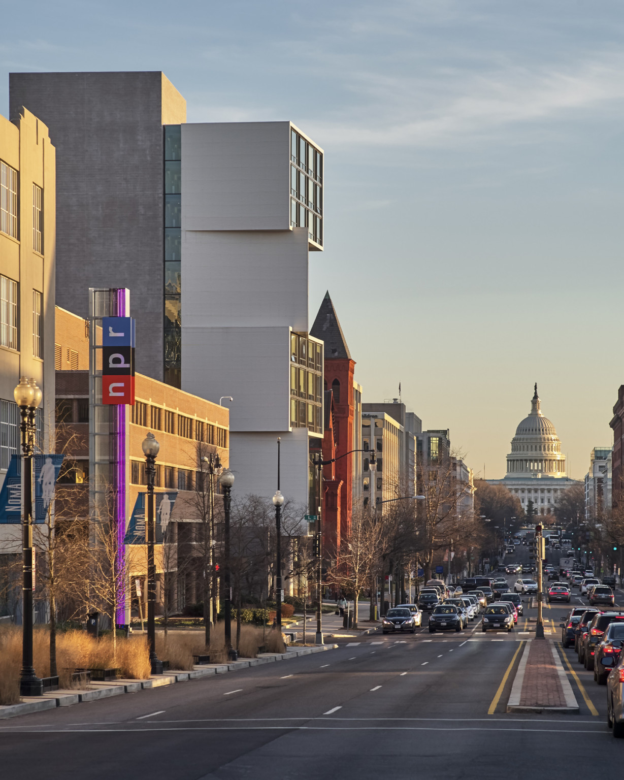 View down capital st to the capital dome full of vehicular and pedestrian traffic in washington dc against a sunset sky