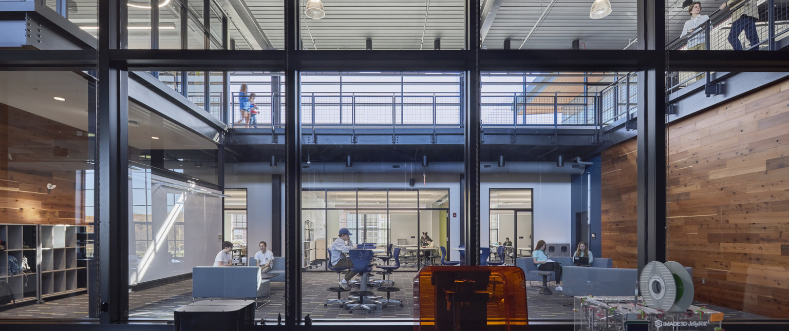 learning atrium surrounded by an elevated walkway built out of black steal, robotics equipment in view