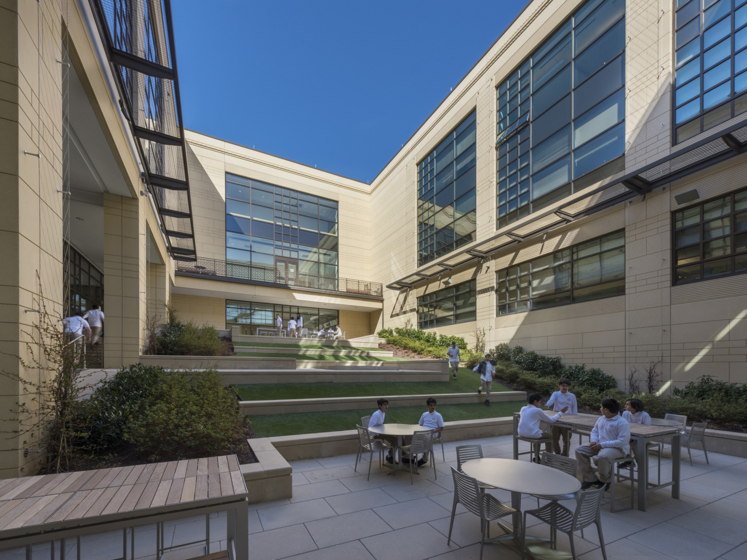 enclosed outdoor green space with tables and different seating areas forming large stairs up the greenway