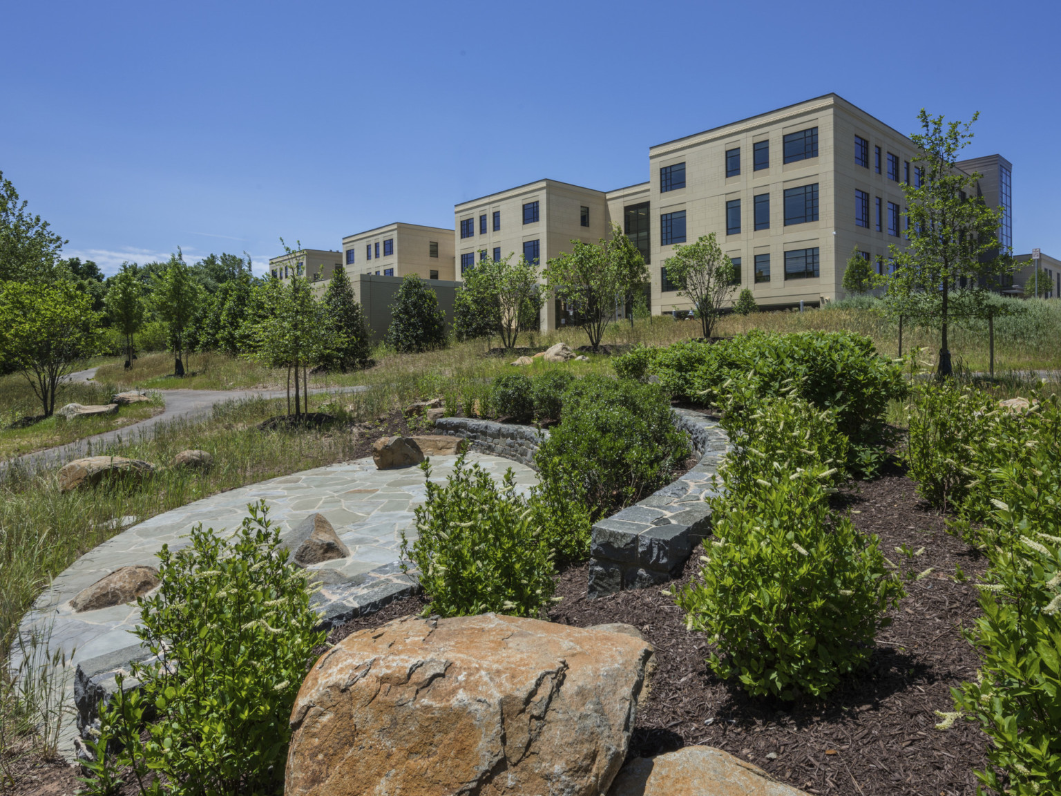 an outdoor community area with stone seating just outside building with precast concrete exterior façade