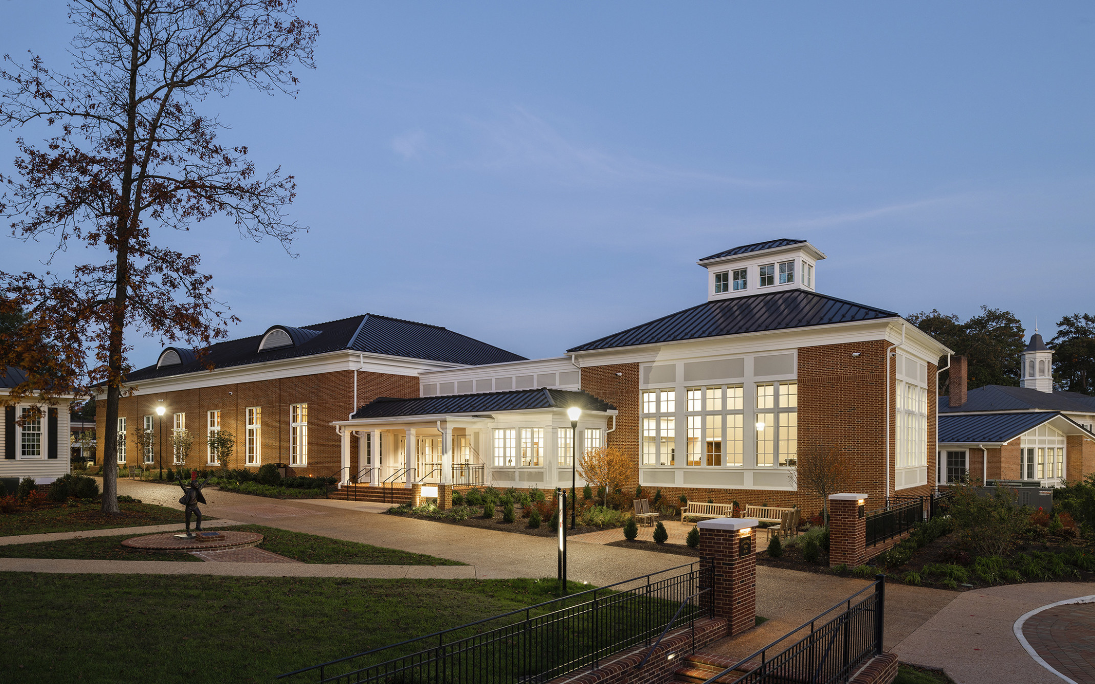 federal style brick buildings with black metal roof and eyebrow dormers and white trim and windows with white mullions